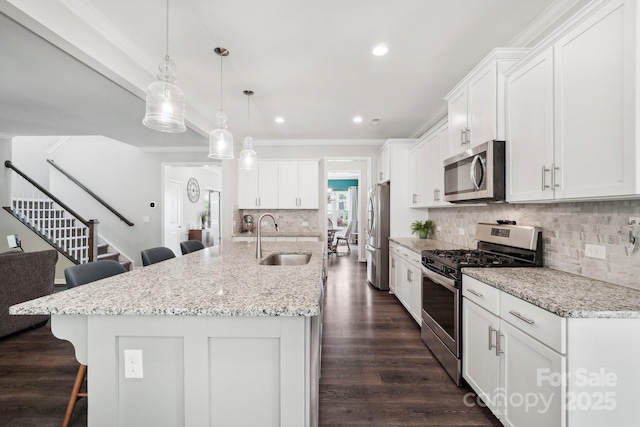3218 Gilroy Dr, Fort Mill, SC 29707 - kitchen featuring stainless steel appliances, a sink, a breakfast bar area, white cabinetry, and ornamental molding