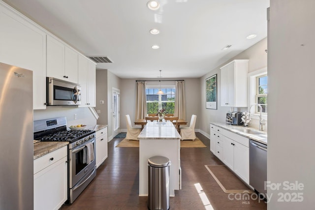 19 Wetland Way, Arden, NC 28704 - kitchen featuring appliances with stainless steel finishes, a sink, white cabinets, light stone countertops, and dark wood-style flooring