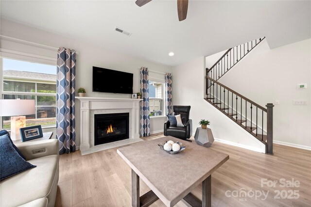 1918 Thoreau Way, York, SC 29745 - living area featuring light wood-type flooring, stairs, a fireplace with flush hearth, a ceiling fan, and baseboards