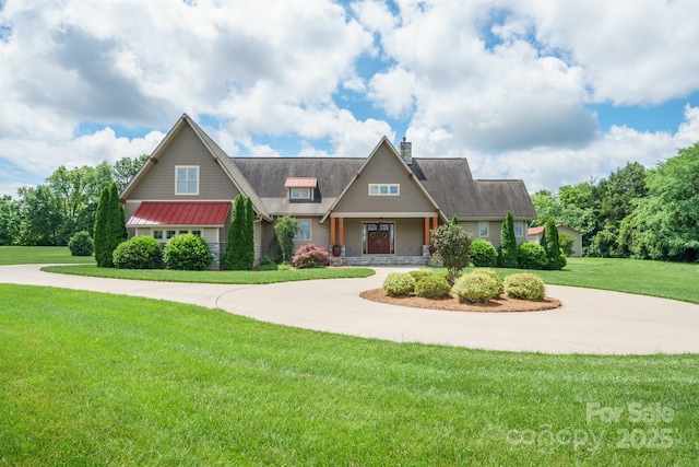 craftsman inspired home with a front yard, a chimney, curved driveway, and a standing seam roof