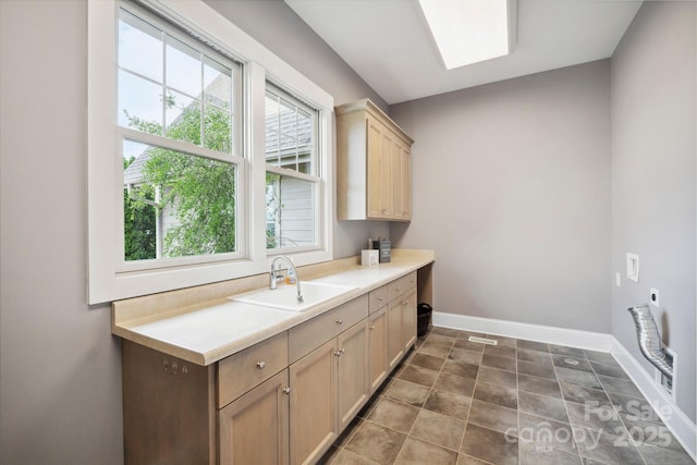 clothes washing area with cabinet space, hookup for an electric dryer, and baseboards