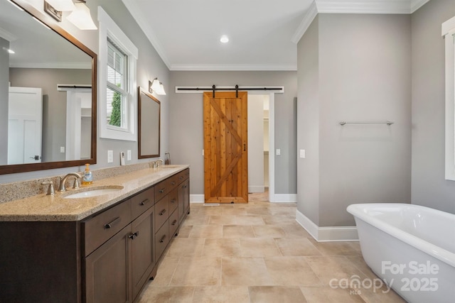 full bath with baseboards, a freestanding bath, double vanity, ornamental molding, and recessed lighting