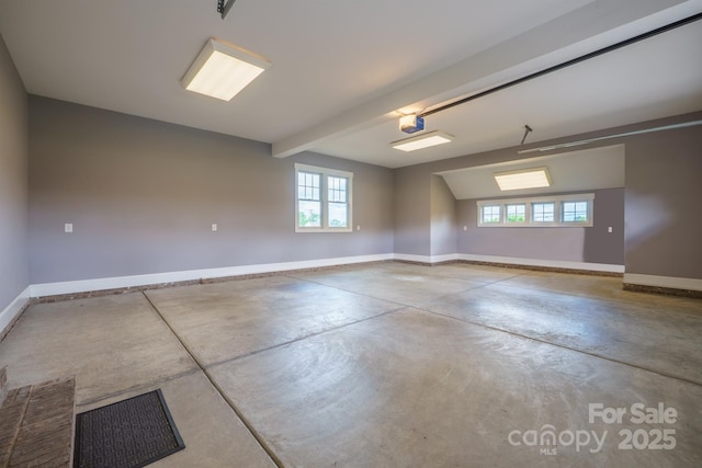 unfurnished room featuring concrete flooring, baseboards, and plenty of natural light