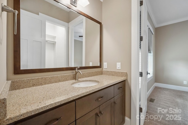 bathroom featuring ornamental molding, vanity, and baseboards