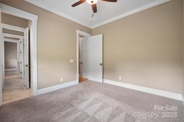 unfurnished bedroom with carpet, crown molding, baseboards, and ceiling fan