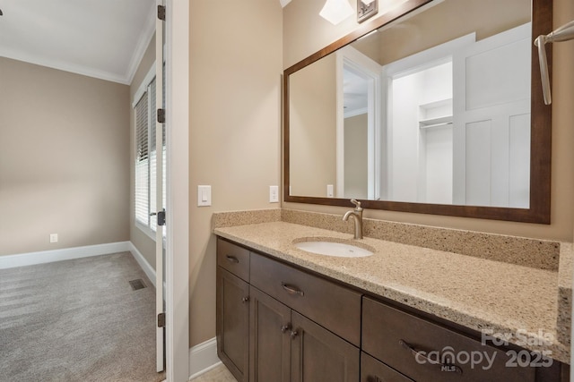bathroom featuring ornamental molding, baseboards, and vanity