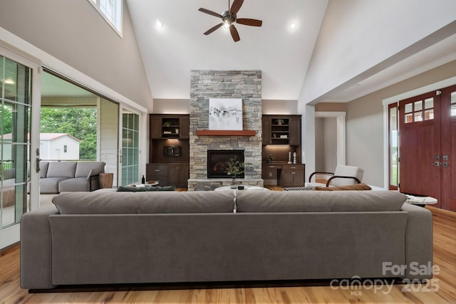 living room with high vaulted ceiling, ceiling fan, healthy amount of natural light, a stone fireplace, and recessed lighting