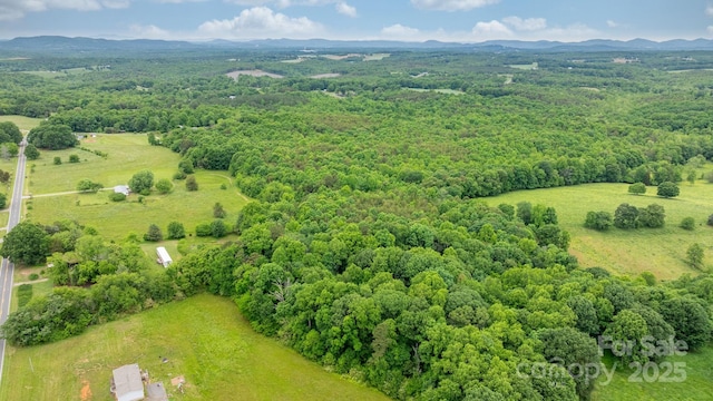 aerial view of a mountainous background and a heavily wooded area