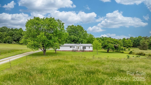 view of green lawn featuring a view of rural / pastoral area