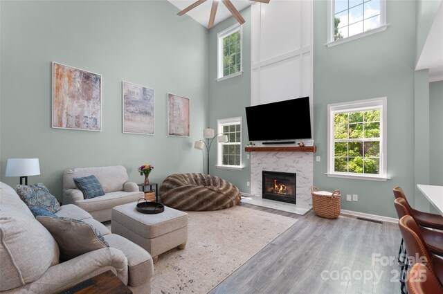8 Secrest Dr, Arden, NC 28704 - living room with a towering ceiling, a ceiling fan, wood finished floors, a high end fireplace, and plenty of natural light