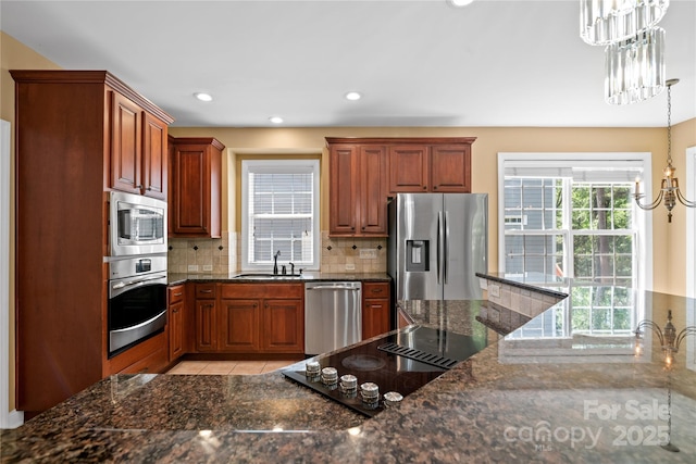 10616 Back Ridge Rd, Charlotte, NC 28277 - kitchen with appliances with stainless steel finishes, a sink, a chandelier, backsplash, and light tile patterned flooring