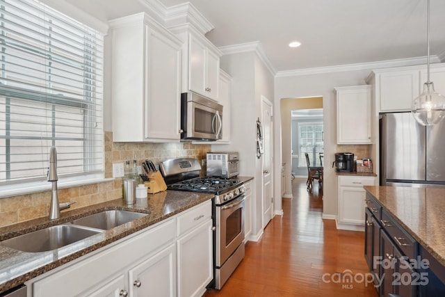 10401 Royal Winchester Dr, Charlotte, NC 28277 - kitchen with appliances with stainless steel finishes, a sink, white cabinets, backsplash, and ornamental molding