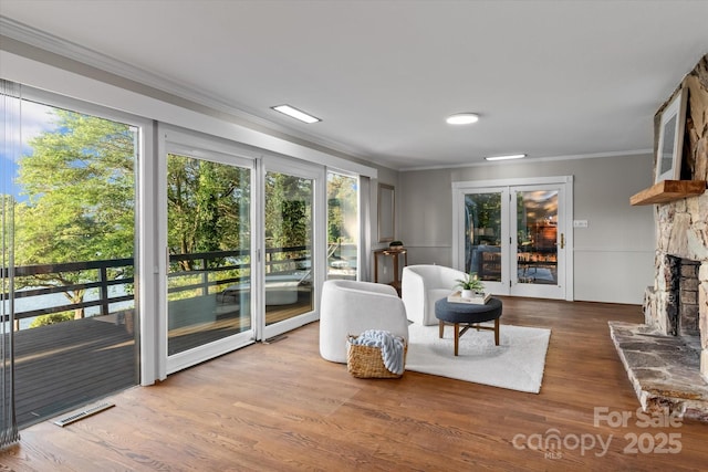 230 Shady Cove Rd, Troutman, NC 28166 - sitting room with crown molding, a stone fireplace, and wood finished floors