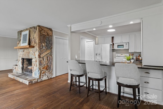 230 Shady Cove Rd, Troutman, NC 28166 - kitchen featuring white appliances, crown molding, dark countertops, white cabinets, and dark wood-style flooring