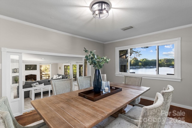 230 Shady Cove Rd, Troutman, NC 28166 - dining room featuring wood finished floors, crown molding, baseboards, and a fireplace