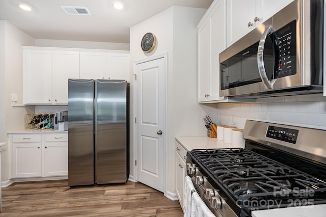 6011 Chelsea Oaks Rdg, Tega Cay, SC 29708 - kitchen featuring appliances with stainless steel finishes, recessed lighting, light countertops, white cabinetry, and wood finished floors