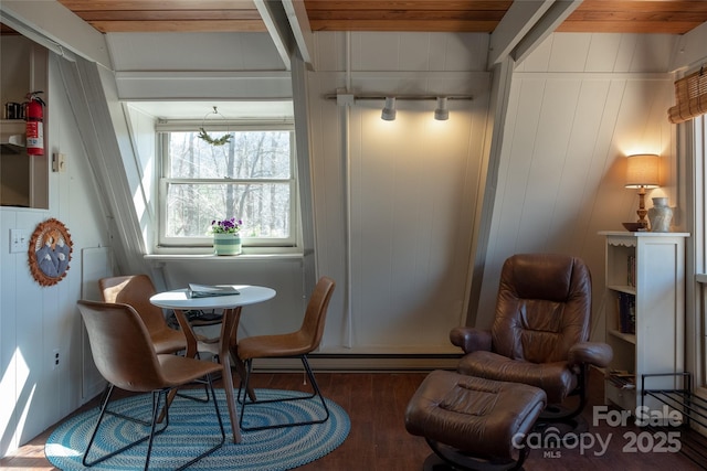 dining room featuring wood finished floors, wood ceiling, and wooden walls