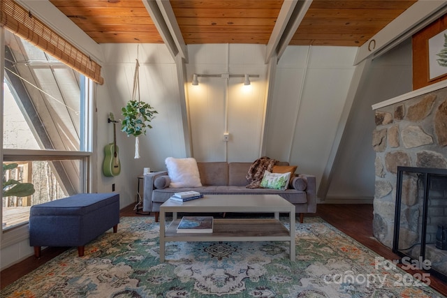 living area featuring wood finished floors, wood ceiling, a fireplace, and beamed ceiling