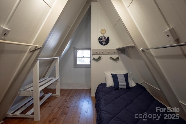 bedroom with wood-type flooring, baseboards, and vaulted ceiling