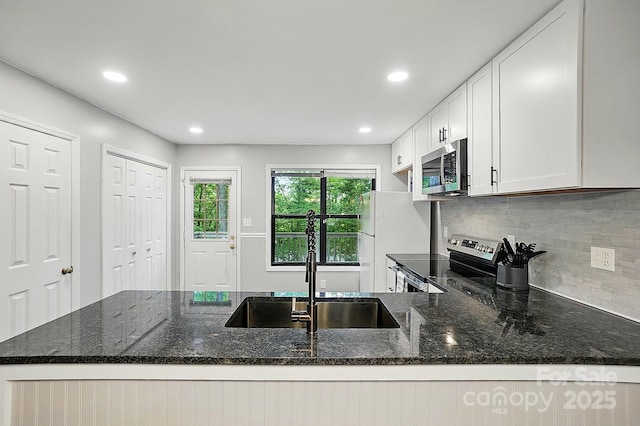 392 Tall Oaks Trl, Fort Mill, SC 29715 - kitchen featuring stainless steel appliances, a sink, dark stone countertops, backsplash, and a peninsula