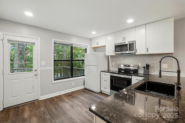 392 Tall Oaks Trl, Fort Mill, SC 29715 - kitchen with stainless steel appliances, a sink, dark wood-style flooring, white cabinetry, and decorative backsplash
