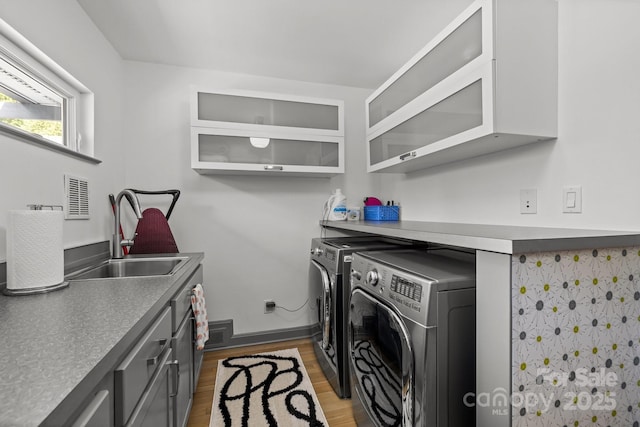 2121 Valencia Ter, Charlotte, NC 28226 - clothes washing area featuring washing machine and dryer, cabinet space, light wood finished floors, and baseboards