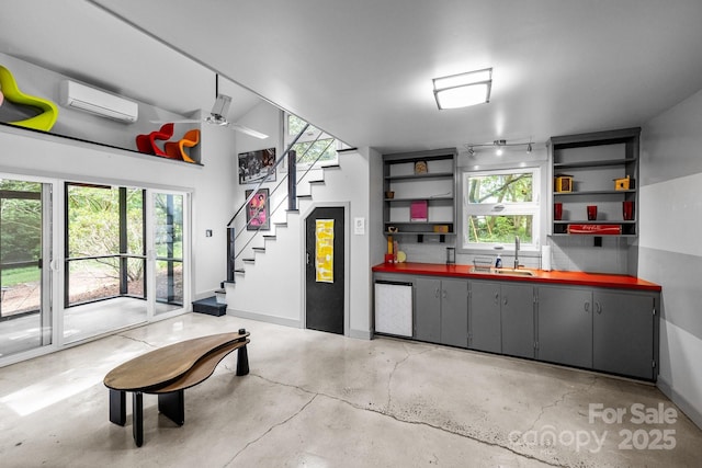 2121 Valencia Ter, Charlotte, NC 28226 - garage featuring a sink, a wall mounted air conditioner, baseboards, and a ceiling fan