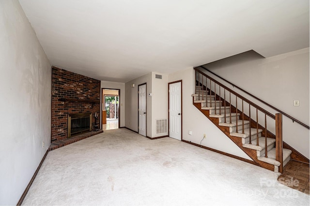 1330 5th St NE Unit 145, Hickory, NC 28601 - unfurnished living room with stairway, carpet floors, a brick fireplace, and baseboards