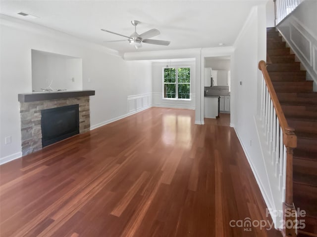 1184 Lempster Dr NW, Concord, NC 28027 - unfurnished living room with a stone fireplace, stairs, a ceiling fan, wood finished floors, and baseboards