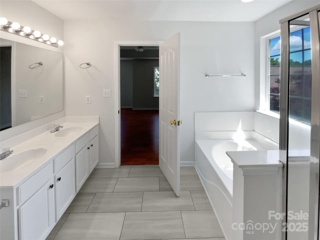 1184 Lempster Dr NW, Concord, NC 28027 - bathroom featuring tile patterned floors, baseboards, double vanity, and a bath