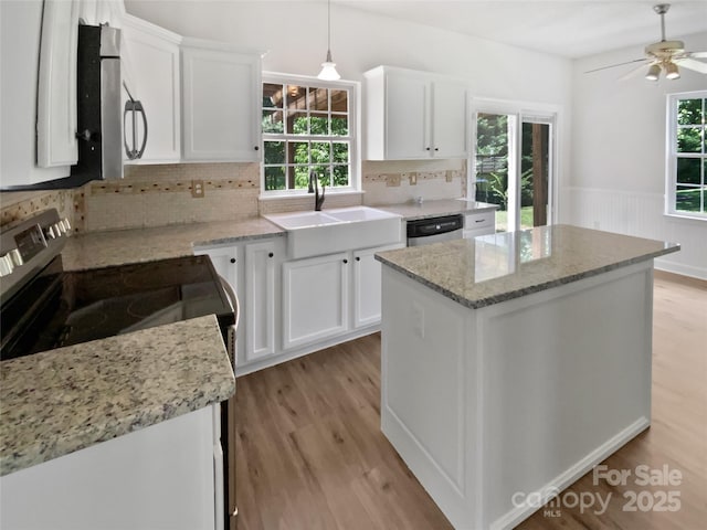 1184 Lempster Dr NW, Concord, NC 28027 - kitchen featuring a sink, appliances with stainless steel finishes, light wood-style flooring, white cabinetry, and tasteful backsplash