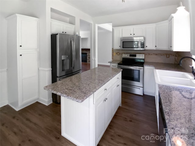 1184 Lempster Dr NW, Concord, NC 28027 - kitchen featuring appliances with stainless steel finishes, a center island, a sink, and white cabinetry