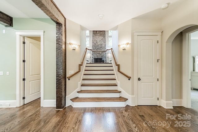 157 Dedham Loop, Mooresville, NC 28117 - staircase with arched walkways, wood finished floors, and baseboards