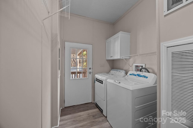 1370 Poole Rd, Salisbury, NC 28146 - laundry room with cabinet space, washing machine and dryer, ornamental molding, light wood-style flooring, and a textured ceiling