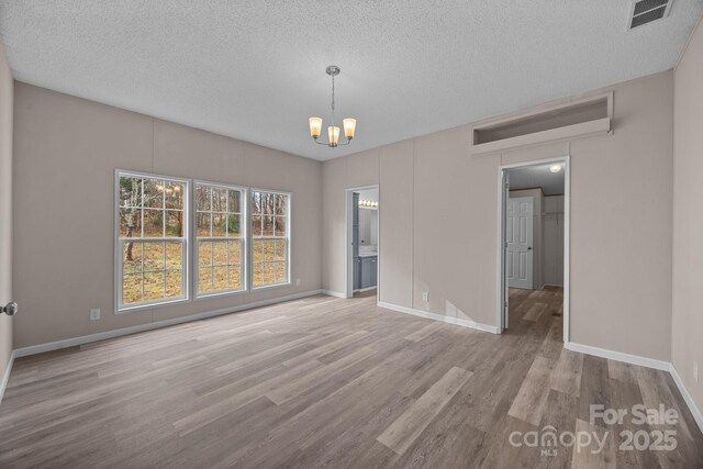 1370 Poole Rd, Salisbury, NC 28146 - unfurnished dining area with a chandelier, wood finished floors, baseboards, and a textured ceiling