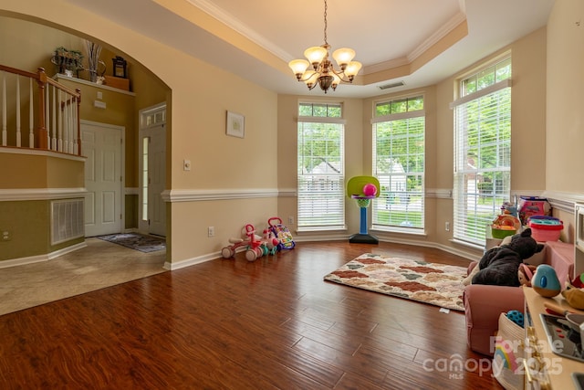5656 Cambridge Bay Dr, Charlotte, NC 28269 - game room with a raised ceiling, a chandelier, ornamental molding, wood finished floors, and arched walkways