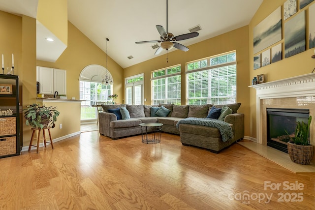 5656 Cambridge Bay Dr, Charlotte, NC 28269 - living room with high vaulted ceiling, light wood-style flooring, ceiling fan, healthy amount of natural light, and a fireplace