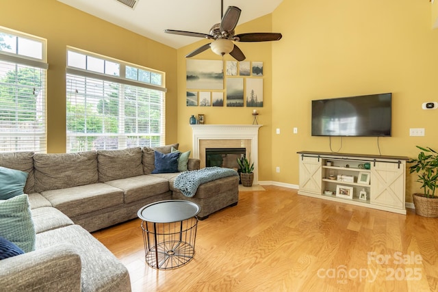 5656 Cambridge Bay Dr, Charlotte, NC 28269 - living room featuring a ceiling fan, wood finished floors, high vaulted ceiling, and a fireplace with flush hearth