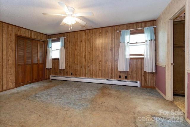 67 Old Turkey Creek Rd, Leicester, NC 28748 - carpeted empty room with a baseboard heating unit, a ceiling fan, and wood walls