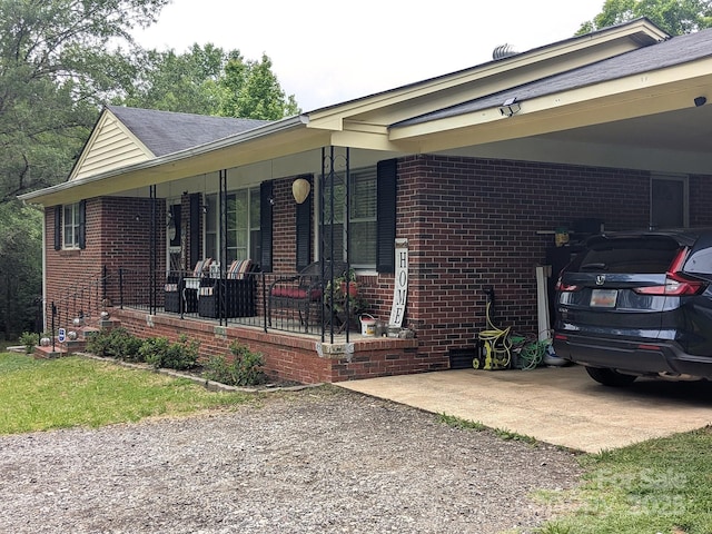 3116 Pilgrim Rd, Chester, SC 29706 - view of home's exterior with brick siding, gravel driveway, covered porch, and an attached carport