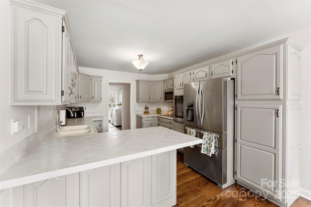 148 Fairway Dr, Forest City, NC 28043 - kitchen with stainless steel appliances, a sink, a peninsula, and dark wood-style floors