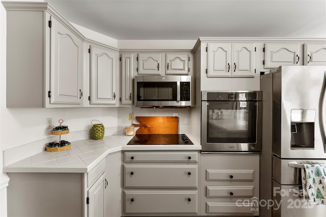 148 Fairway Dr, Forest City, NC 28043 - kitchen with appliances with stainless steel finishes, decorative backsplash, and tile countertops