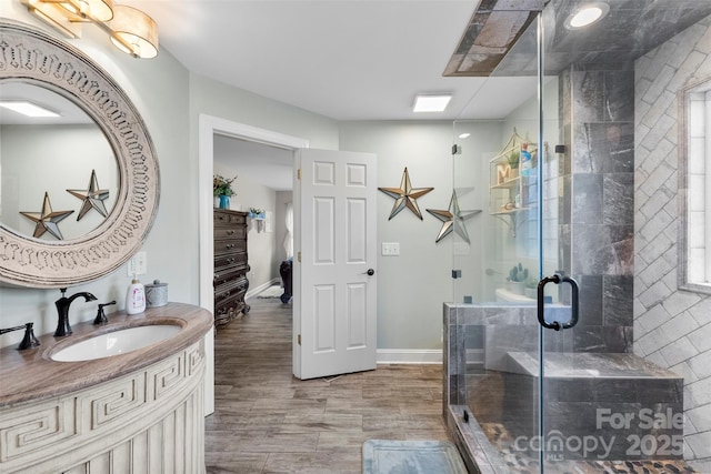 148 Fairway Dr, Forest City, NC 28043 - bathroom featuring a stall shower, vanity, baseboards, and wood finished floors