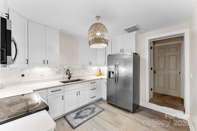 148 Fairway Dr, Forest City, NC 28043 - kitchen with stainless steel fridge with ice dispenser, a sink, white cabinets, and a chandelier
