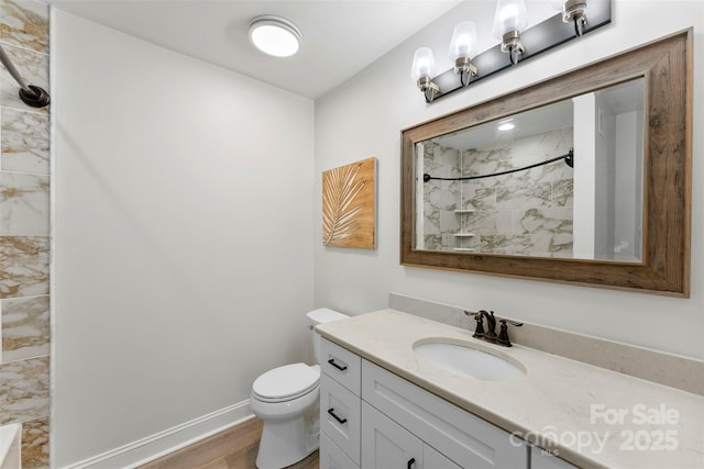 148 Fairway Dr, Forest City, NC 28043 - bathroom featuring a tile shower, wood finished floors, toilet, vanity, and baseboards