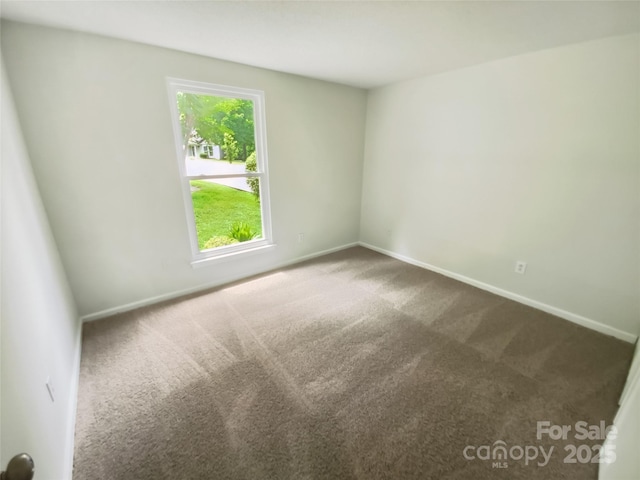spare room with carpet and baseboards