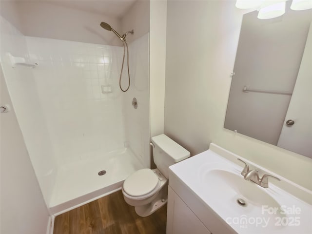 full bathroom featuring wood finished floors, vanity, toilet, and a shower