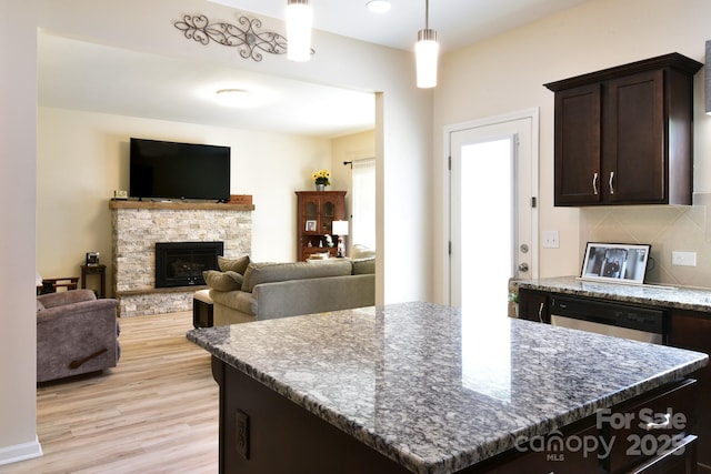 161 Old Harbor Dr, Mount Gilead, NC 27306 - kitchen featuring light wood-style flooring, dark brown cabinetry, dark stone countertops, decorative light fixtures, and dishwashing machine