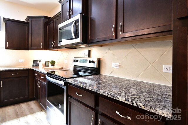 161 Old Harbor Dr, Mount Gilead, NC 27306 - kitchen with appliances with stainless steel finishes, dark stone countertops, light wood-style floors, and dark brown cabinetry