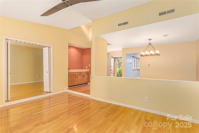 111 Clubwood Ct, Asheville, NC 28803 - spare room featuring light wood-style flooring, a chandelier, and baseboards
